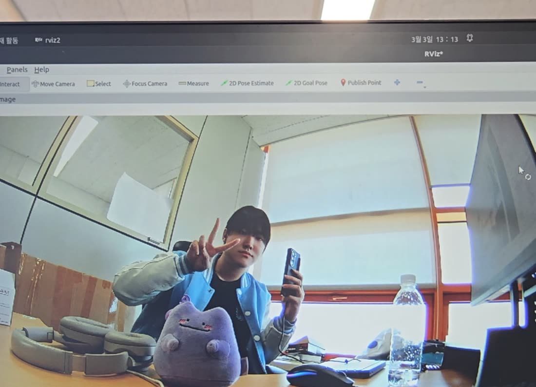 Me caught on an RViz2 camera feed, throwing a V next to my own autonomy rig